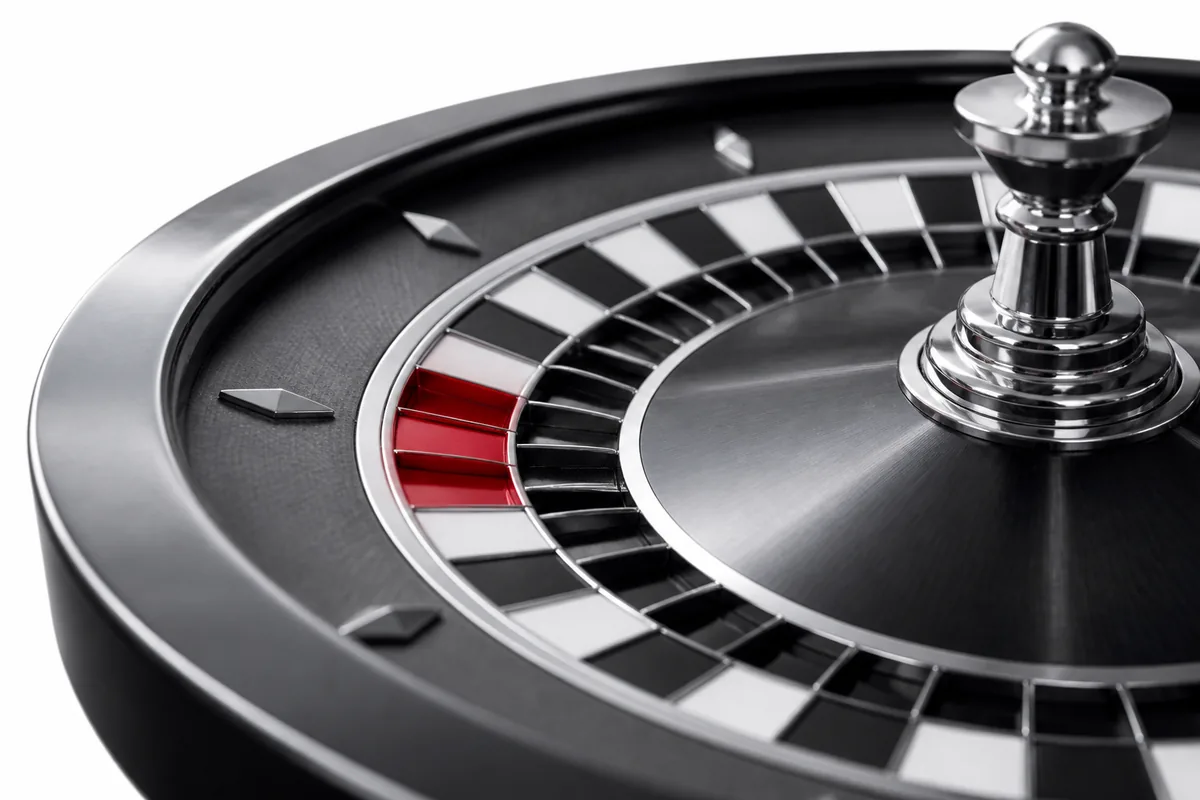 Detalle de una rueda de ruleta en escala de grises con un casillero rojo